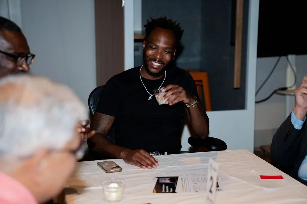 Smiling man seated at a table during a networking event